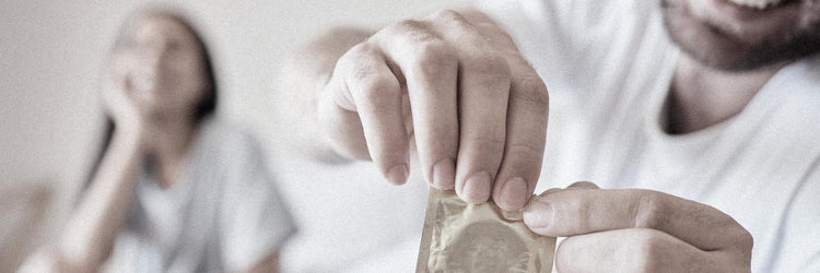 Man opening a condom wrapper