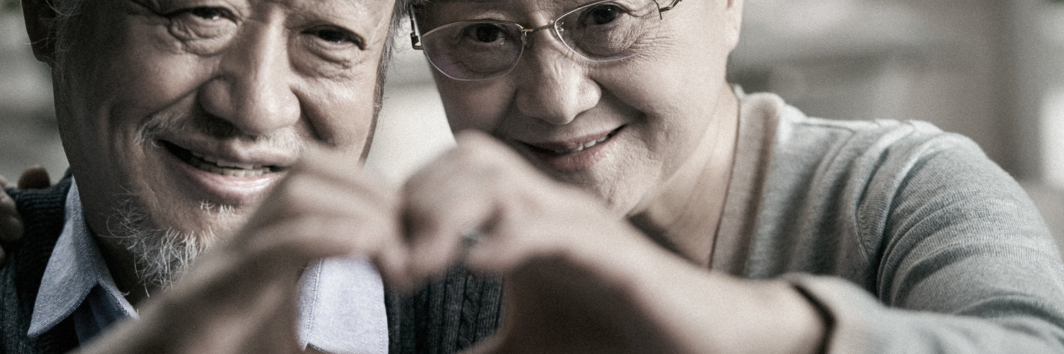 Man and woman peeking out from under a blanket