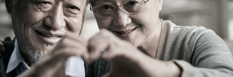 Man and woman peeking out from under a blanket